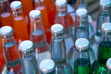 A closeup of the neck of a bottle. group of lemonade bottles