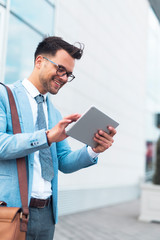 Businessman in suit using tablet.