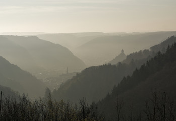 View over Mosel river in Germany with Cochem Castle and misty hills