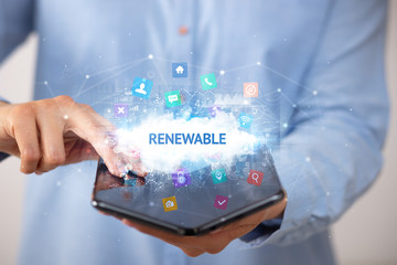 Businessman holding a foldable smartphone with RENEWABLE inscription, technology concept