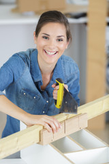a happy woman cutting wood