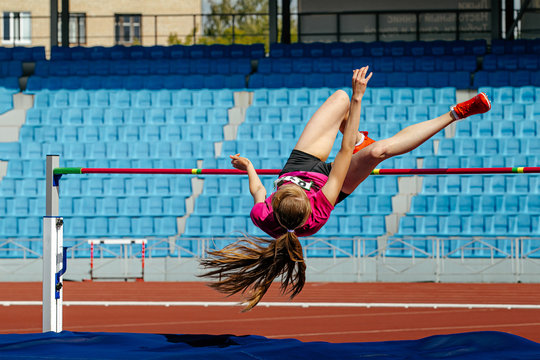 Woman Athlete Jumper High Jump At Stadium On Background Of Spectator Seats