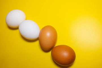 White and brown Easter eggs bright yellow background. Concept happy Easter. Minimalism concept. Top view.