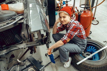 Smiling pretty Caucasian female mechanic looking away