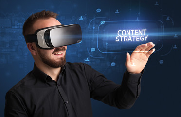 Businessman looking through Virtual Reality glasses with CONTENT STRATEGY inscription, social networking concept