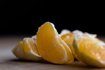Pieces of fresh orange lying on a wooden board