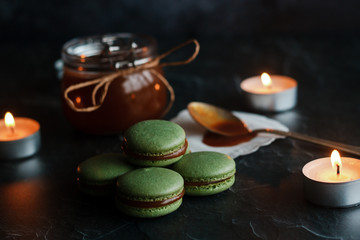 Obraz na płótnie Canvas Macaroons. Delicious french dessert. Romantic composition with a jar of caramel and candles