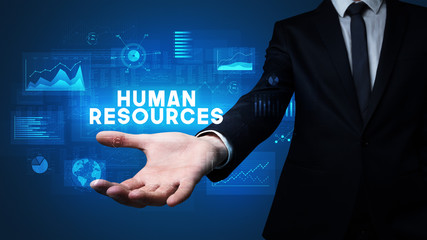 Hand of Businessman holding HUMAN RESOURCES inscription, business success concept
