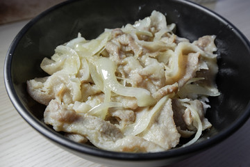 Close-up view of pork belly and onion stir fry.