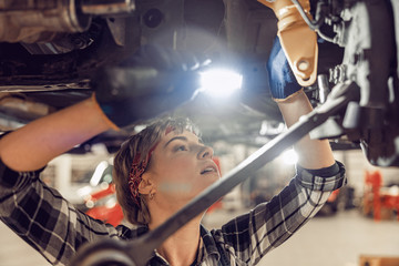 Obraz na płótnie Canvas Serious female mechanic performing a car inspection