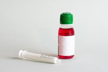 Isolated bottle of paracetamol solution with syriringe for dosification.