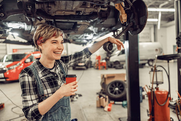 Obraz na płótnie Canvas High-spirited woman standing in an auto workshop