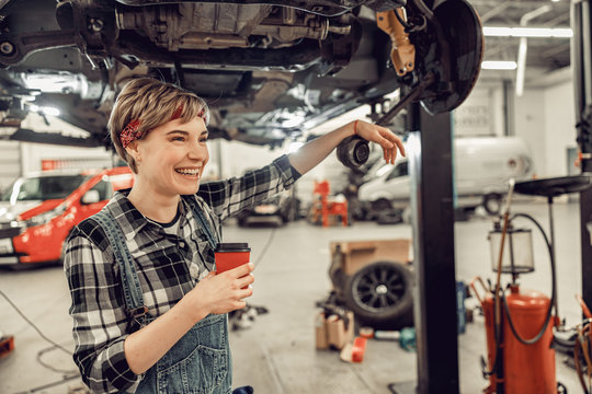 High-spirited woman standing in an auto workshop
