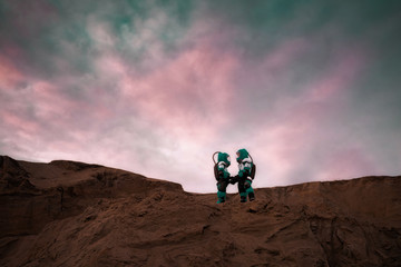 Two Astronauts Wearing Space Suits Holding Hands on Mars/ Red Planet. Love in Space Travel, Exploration and Colonization Concept. © antonkorobkov