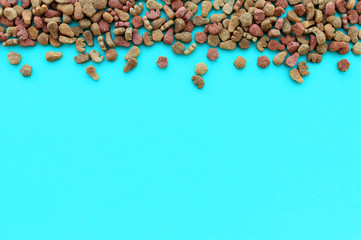 Dry cat food on a blue background with a place for writing. The view from the top