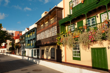 Fototapeta na wymiar Casas con balcones de madera floridos en la avenida Marítima de Santa Cruz de La Palma 