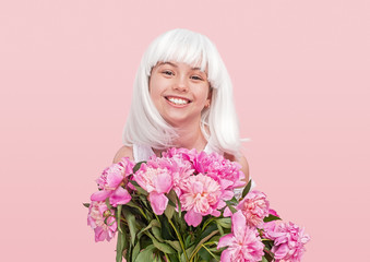 Happy teenager in wig carrying flowers