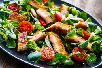 Fried chicken breast and vegetables on wooden table