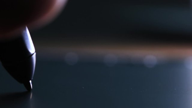 Hand of the designer with a pen on a tablet close up. 
