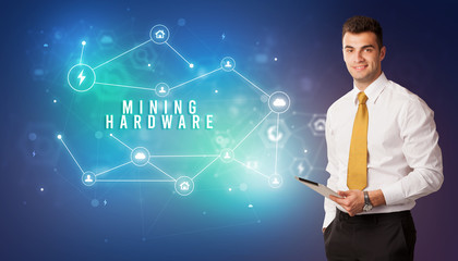 Businessman in front of cloud service icons with MINING HARDWARE inscription, modern technology concept