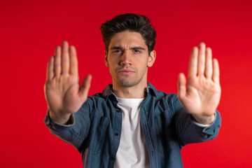 No, never, handsome brunette man disliking and rejecting gesture by stop sign. Portrait of young...