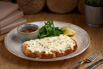 Closeup of a tuna melt topped with cheddar cheese
