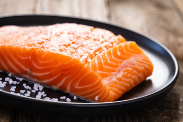 Fresh raw salmon steaks on wooden board