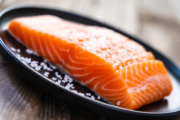 Fresh raw salmon steaks on wooden board