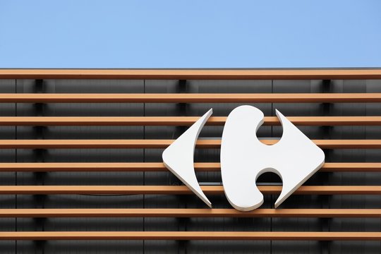 Saint Egreve, France - June 16, 2019: Carrefour sign on a wall. Carrefour is a french multinational retailer headquartered in France and it is one of the largest hypermarket chains in the world