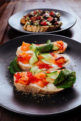 Italian Appetizer Bruschetta with roasted tomatoes, mozzarella cheese, garlic and herbs on wooden table