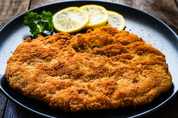 Schnitzel with  lemon on timber background