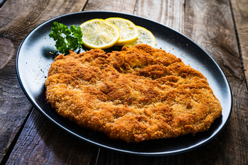 Schnitzel with  lemon on timber background