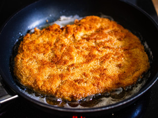 Schnitzel with  lemon on frying pan 