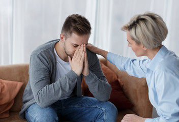 Professional Psychologist Comforting Crying Man During Appointment In Office