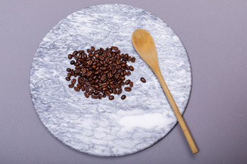 Roasted black coffee beans on marble foil background with good copy space