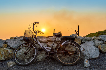 Fototapeta premium old rusty bike with beautiful sun at background