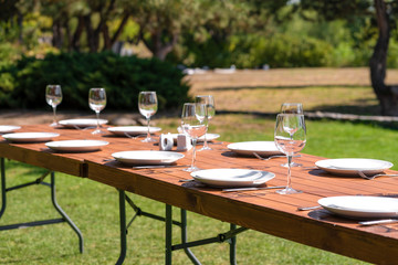 Served wooden table without a tablecloth. Cafe in the open air park