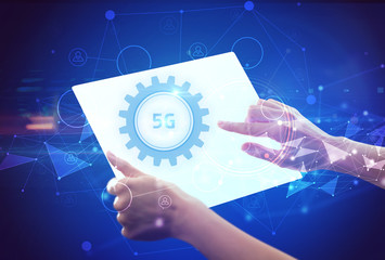 Hand holdig futuristic tablet with 5G inscription, modern technology concept