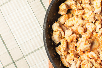 Chopped tender chicken fillet slices cooked in pan with gravy.