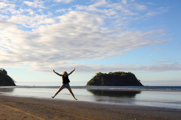 girl, young woman jumping on samara beach, Costa Rica - obrazy, fototapety, plakaty