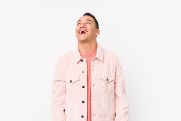 Young latin man posing isolated relaxed and happy laughing, neck stretched showing teeth.