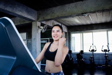 Fototapeta na wymiar Happy Asian woman workout in gym to keep fit and healthy. Good diet and exercise or cardio reduce stress,risk of cancer and weight. Body training make muscle and heart strong.