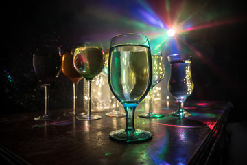 Goblet of white wine on wooden table on wooden wall background