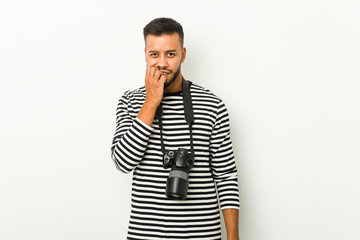 Young south-asian photographer biting fingernails, nervous and very anxious.