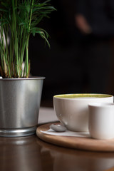 cappuccino, match on a table with syrup and devices, mint latte with a pot of greens