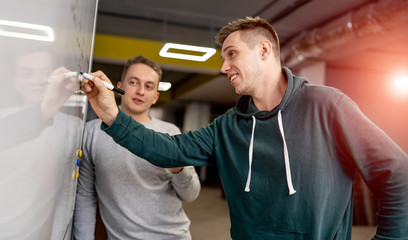 Naklejka premium Creative people meeting at office and use post it notes to share idea. Brainstorming concept. Sticky note on glass wall.