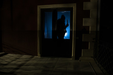 The silhouette of a human in front of a window at night. Scary scene halloween concept of blurred silhouette of maniac.