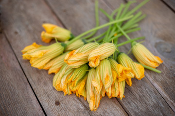 bouquet of Many yellow pumpkin flowers lie on a wooden background