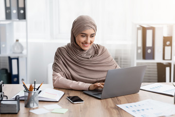Young muslim businesswoman working on her laptop in office