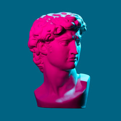 Statue neon. On a blue isolated background. Gypsum statue of David’s head. Man.